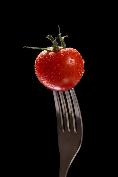 Tomato single with drops isolated on black