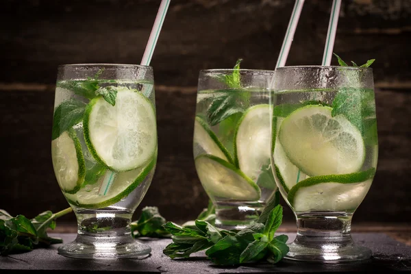 Detox water with a lemon, lime and mint on a wooden table