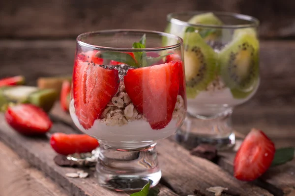Healthy breakfast or morning snack with chia seeds granola, strawberries and kiwi, vegetarian food, diet and health concept