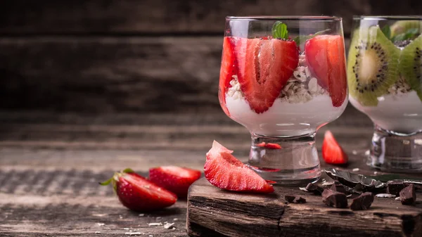 Healthy breakfast or morning snack with chia seeds granola, strawberries and kiwi, vegetarian food, diet and health concept