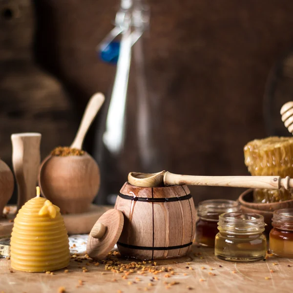 Honey background. Natural honey comb, glass jarand wooden bowls. On wooden rustic table. Soft focus
