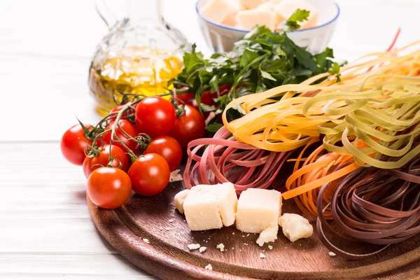 Vegetable color Pasta, oil,tomatoes,cheese on wooden table. italian food