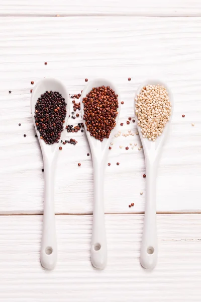 Red, black and white quinoa seeds on a wooden background,healthy food.