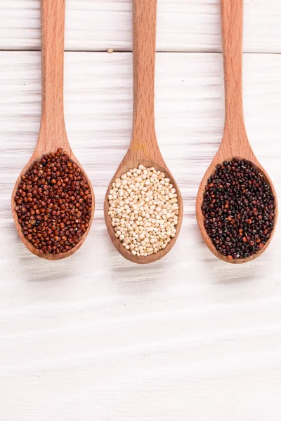 Red, black and white quinoa seeds on a wooden background,healthy food.