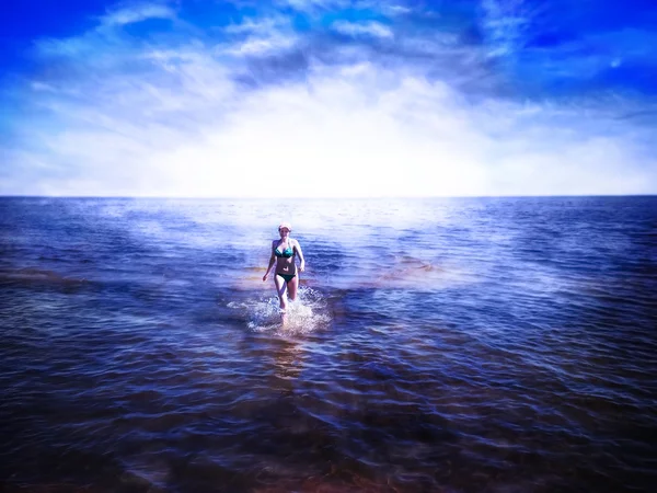 Beautiful girl running on shining water