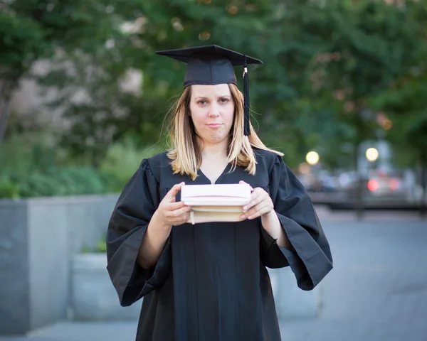 Female college student in graduation day, frowning for being bro
