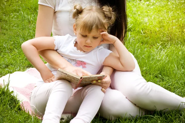 Mom and daughter reading a book together