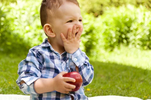 Little boy covered his mouth with his hand so as not to eat the