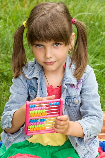 Smart schoolgirl counts on the abacus