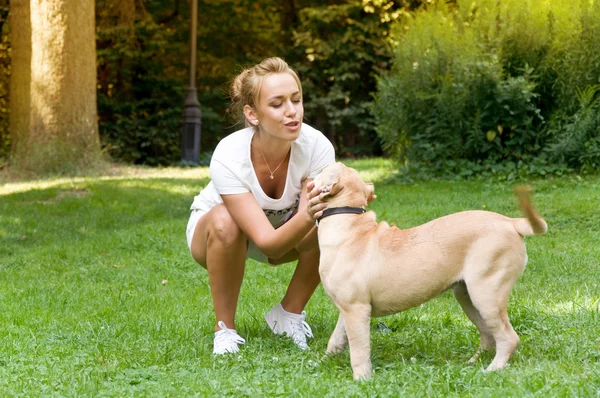 Woman walks in the park with her dog