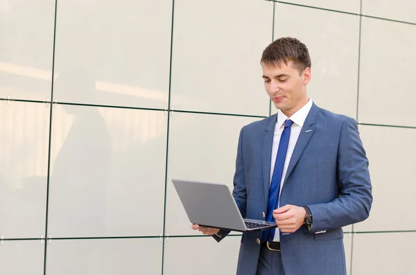 Case in a way. Confident and successful businessman holding a laptop.