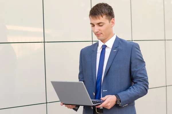 Case in a way. Confident and successful businessman holding a laptop.