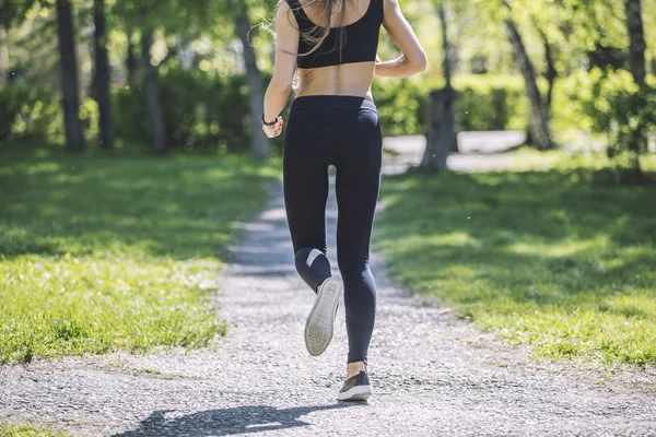 Beautiful young woman in sportswear Jogging in the Park with