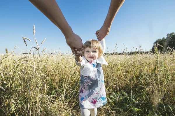 Family, mom, dad holding the daughter hands happy and beautiful