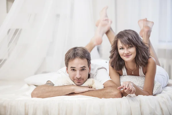 Couple man and woman lay cuddling on the bed at home