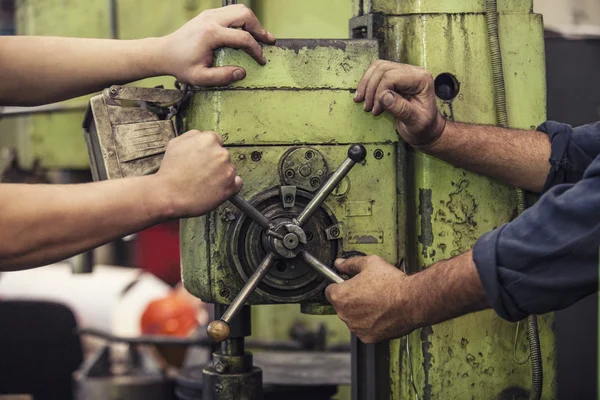 Male hands working twist the lever on the machine in an old fact