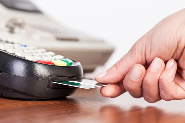 Hand push credit card Into a credit card machine.