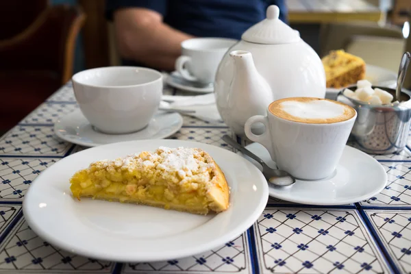 Table setting in a cafe with apple cake cappuccino and saucer