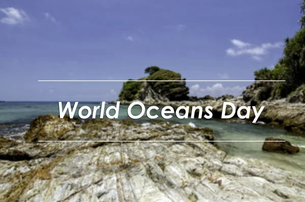 Image concept with word WORLD OCEANS DAY.blurred background stunning sea view with rocky beach