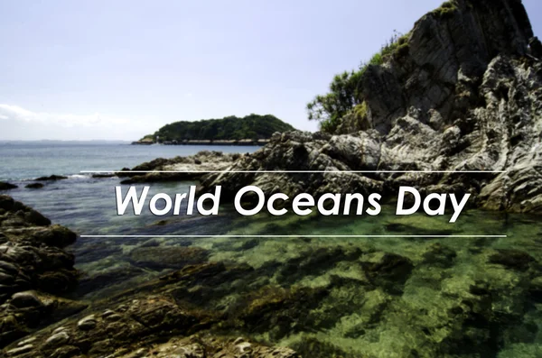 Image concept with word WORLD OCEANS DAY.blurred background beautiful nature sea view from the rocky shore. clear water surrounded the island at sunny day.