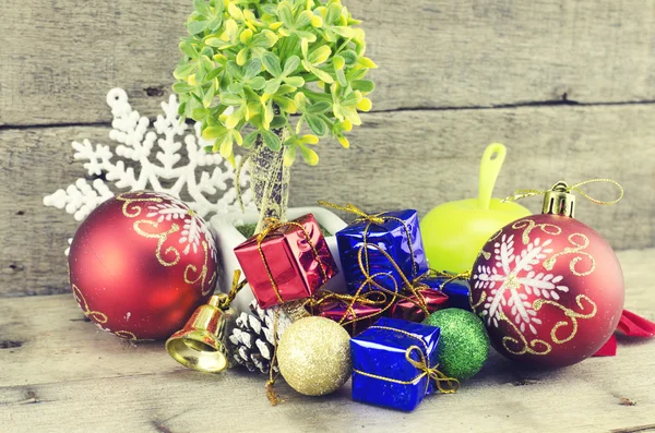 Cropped image of big red ball, artificial tree, pine cone, white snowflakes, golden bell, red and blue gift box