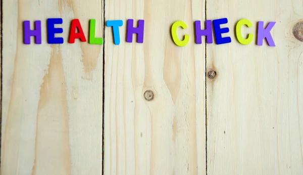 Health check colorful text with copy space on wood table background