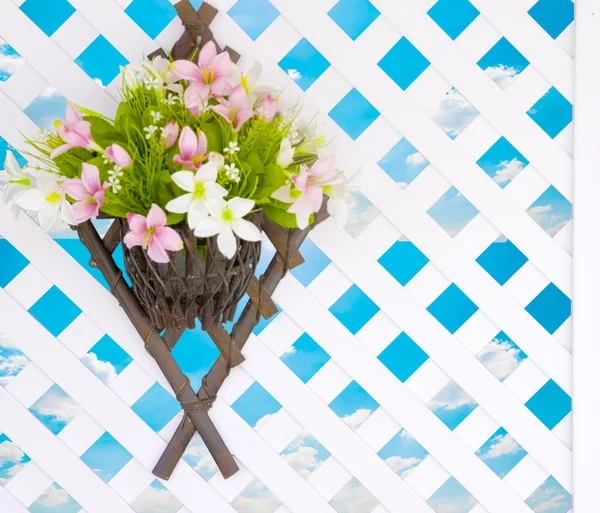 The colorful flower bouquet hanging on fence with blue sky in background (including clipping path)