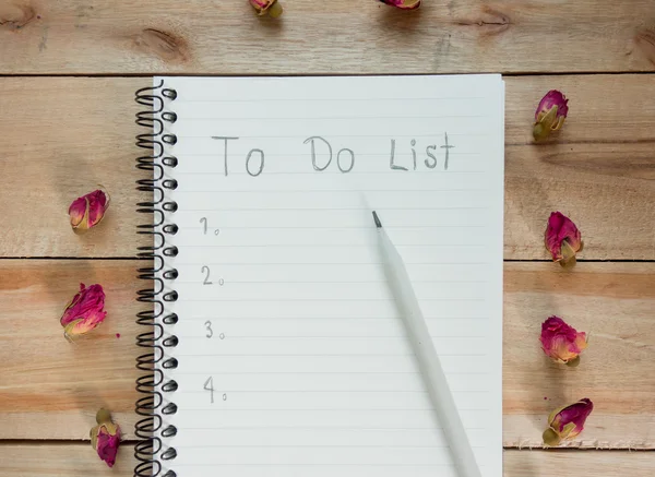 To do list notebook with red rose  on wood floor , digital effect vintage style