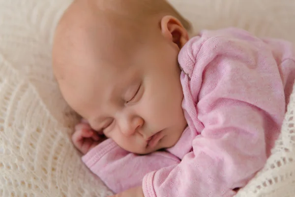 Closeup newborn baby sleeping on white blanket satisfied