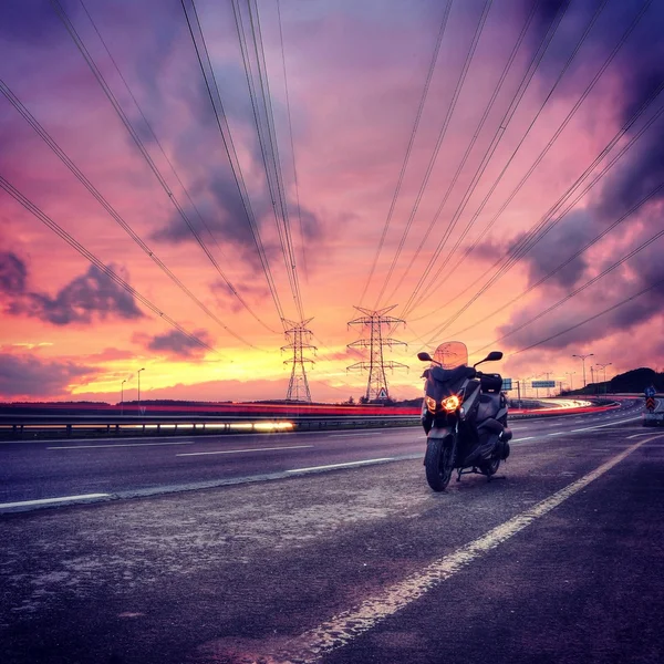 Motorbike on road at sunset