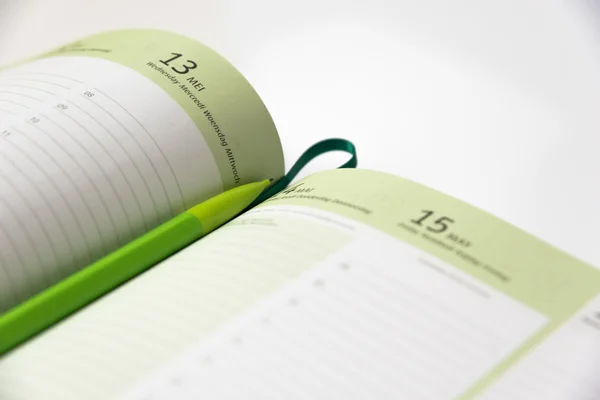 Green pencil on a calendar book