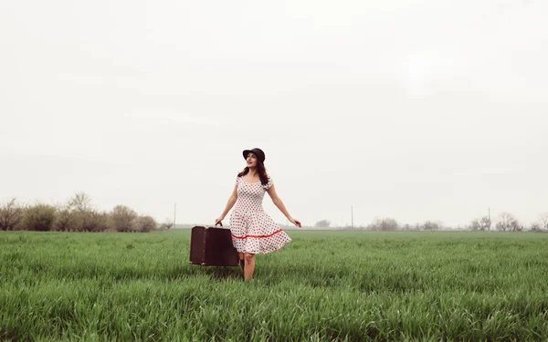 Woman in vintage clothes with suitcase