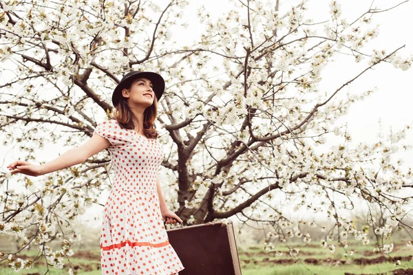 Female in vintage clothes with suitcase