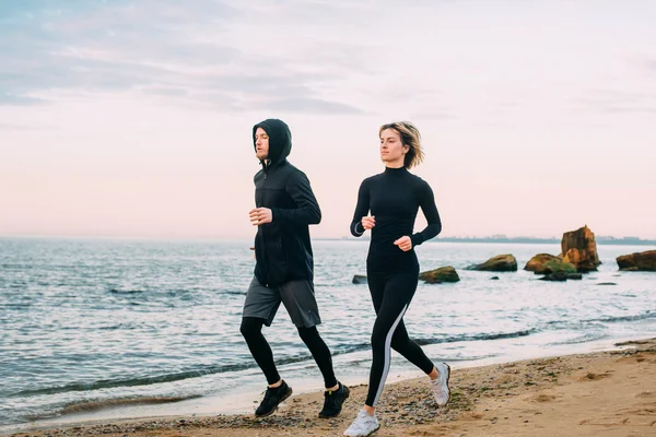 Fitness couple running on beach
