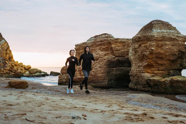 Fitness couple running on beach