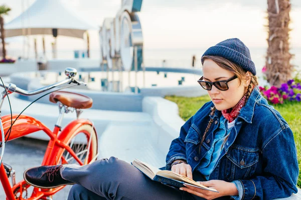 Woman with bicycle resting on seaside