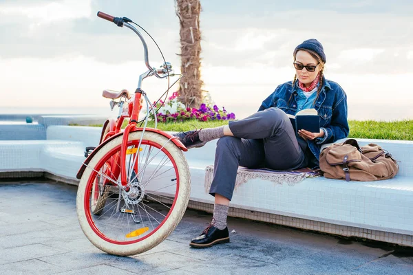 Woman with bicycle resting on seaside