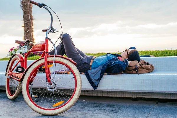 Woman with bicycle resting on seaside