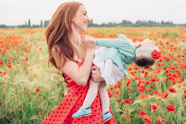 Mother and daughter in poppy field