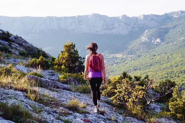 Happy young female hiking in mountains. healthy and active lifestyle. beautiful girl on nature background