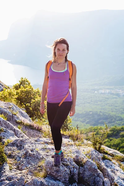 Happy young female hiking in mountains. healthy and active lifestyle. beautiful girl on nature background