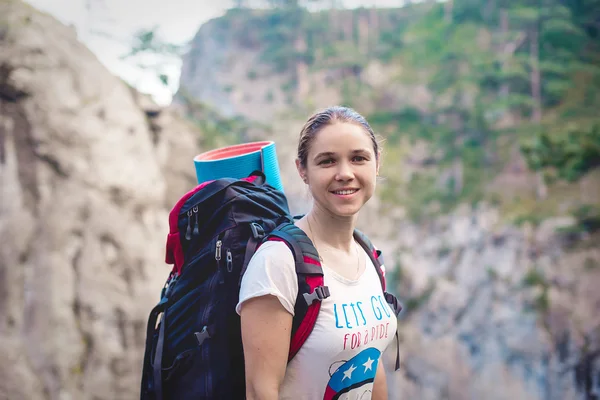 Caucasian hiker woman on trek in mountains with backpack living a healthy active lifestyle. Hiker girl on nature landscape hike in Crimea.