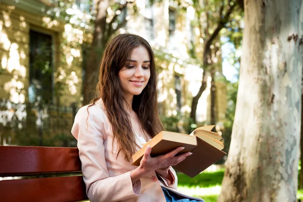 Young caucasian female student with books and tablet on campus, student study in campus area