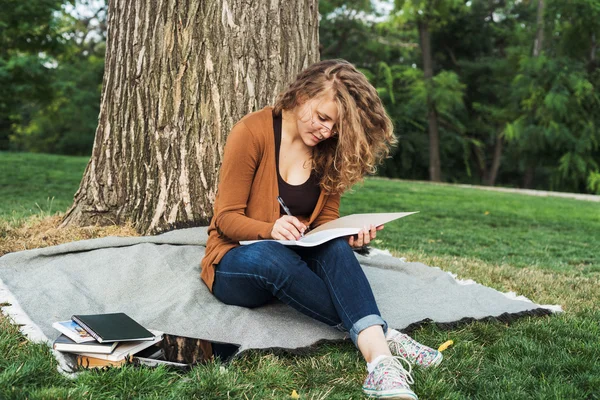 Young caucasian female student with books on campus, student study in campus area
