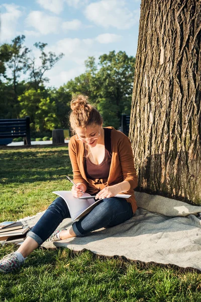 Young caucasian female student with books on campus, student study in campus area