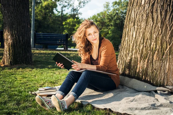 Young caucasian female student with books on campus, student study in campus area