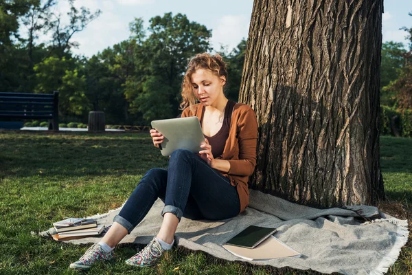 Young caucasian female student with books on campus, student study in campus area