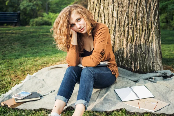 Young caucasian female student with books on campus, student study in campus area