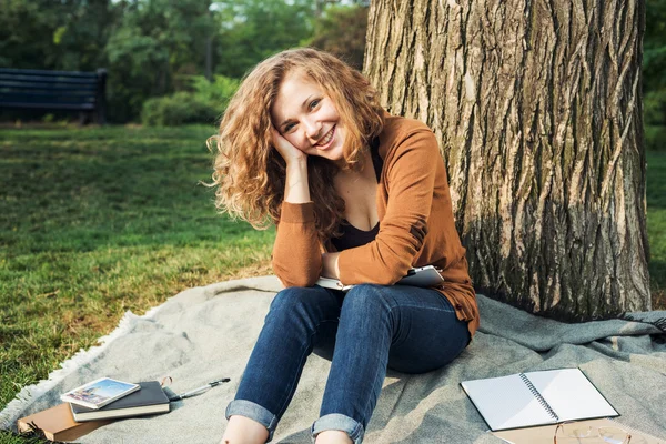 Young caucasian female student with books on campus, student study in campus area