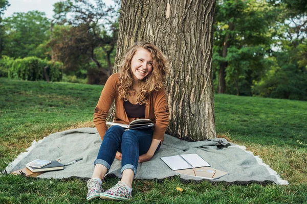 Young caucasian female student with books on campus, student study in campus area